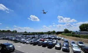 plane flies over car park 540x326